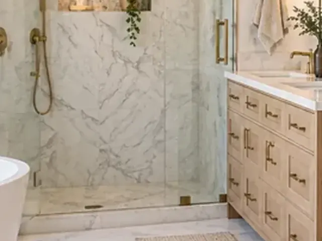 Glass-enclosed walk-in shower with tiled walls and fixtures